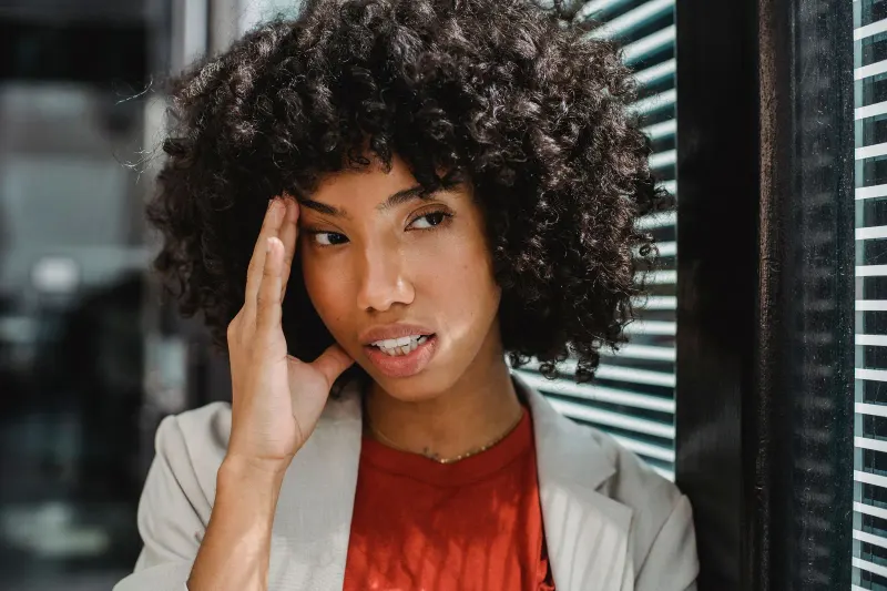 Person experiencing a headache while resting indoors