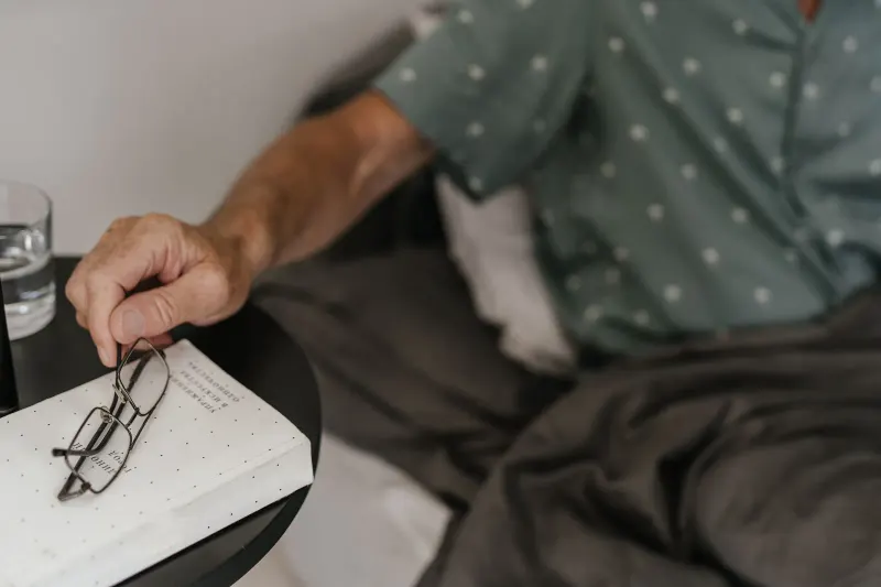 Older adult reading comfortably near a bright window