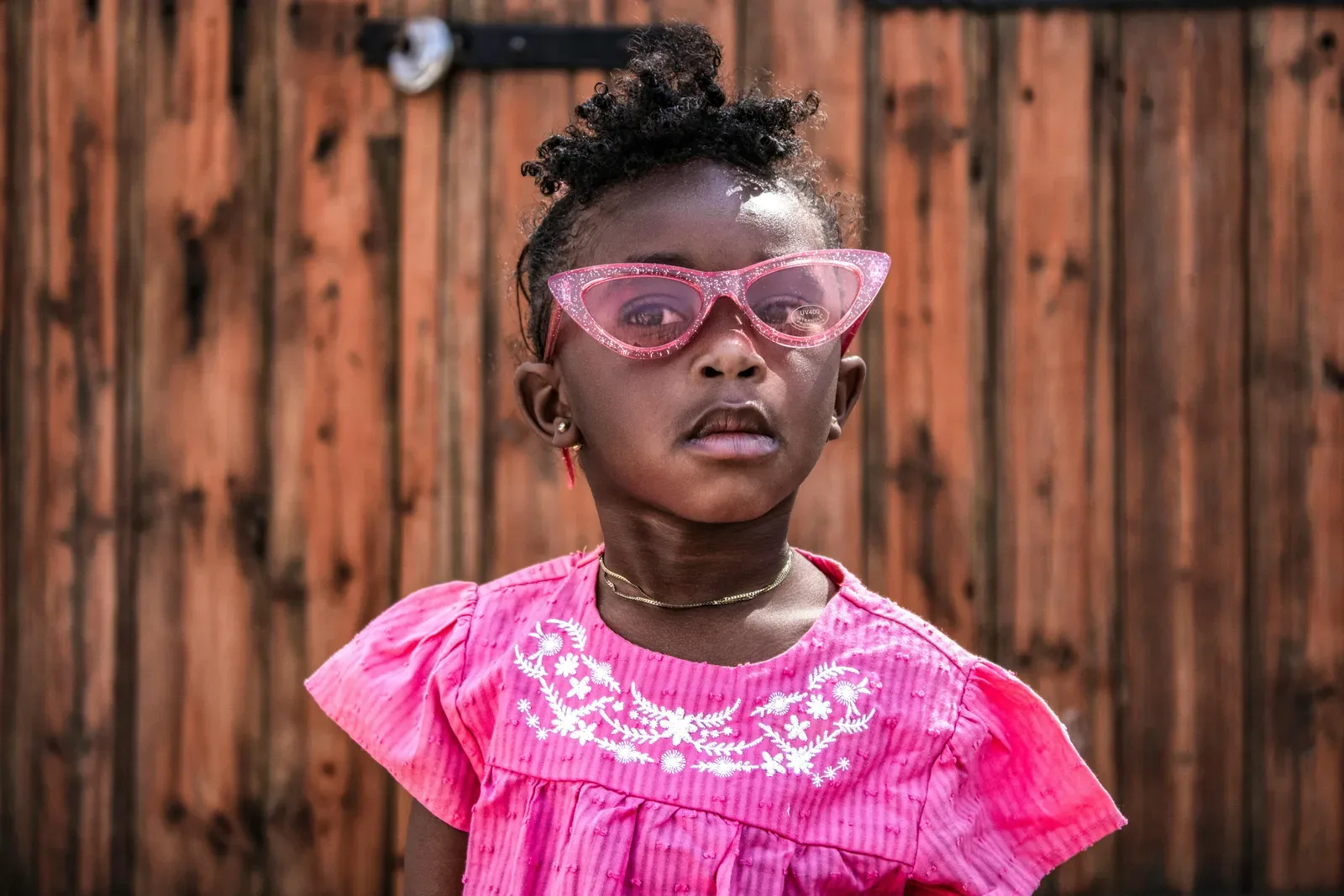 Charming portrait of a stylish young girl in pink sunglasses in South Africa.