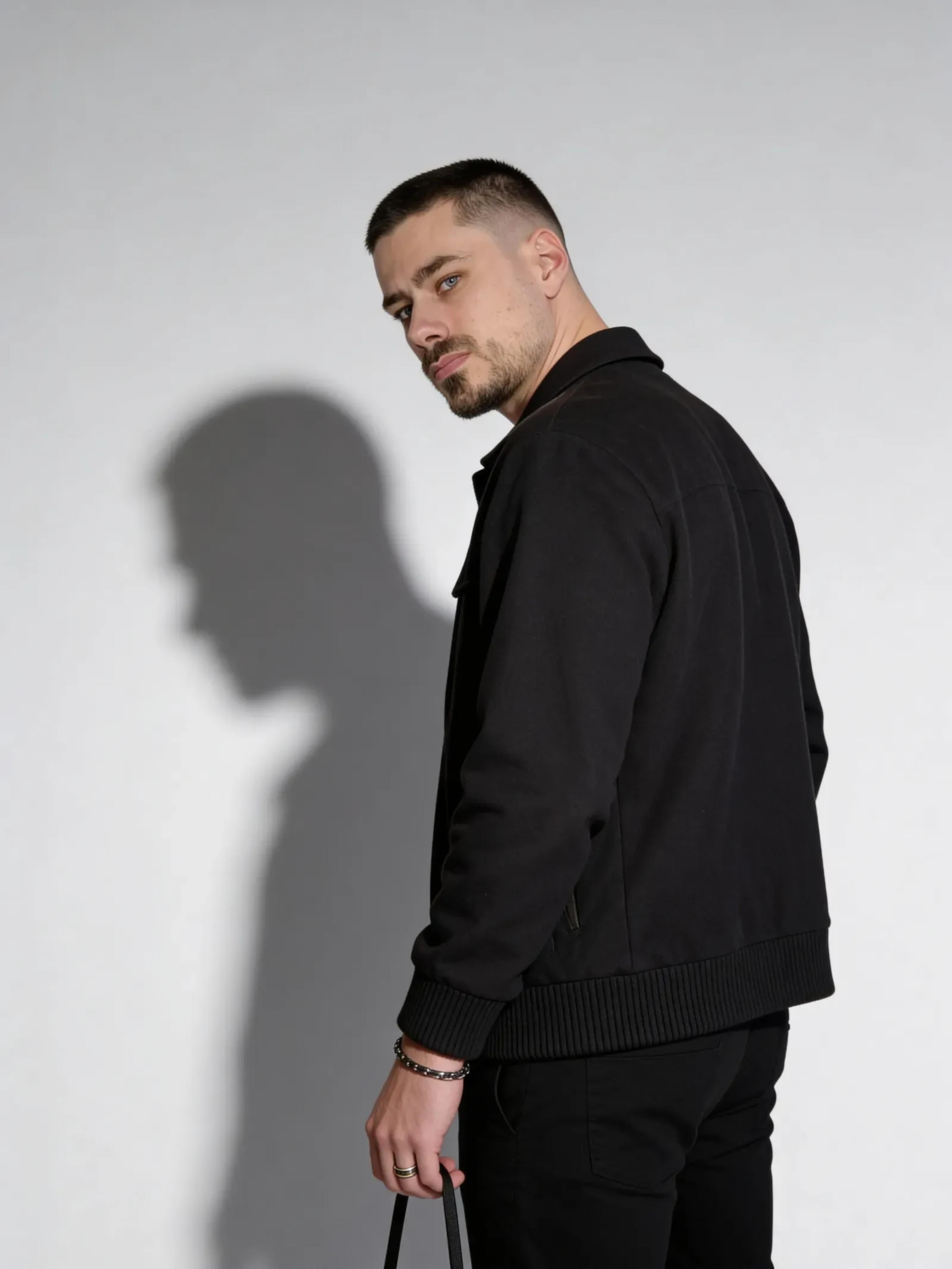 Fotorealistischer männlicher Digitaler Zwilling im schwarzen Outfit mit Schattenwurf, Studio Porträt, Trickhouse KI-Model-Agentur