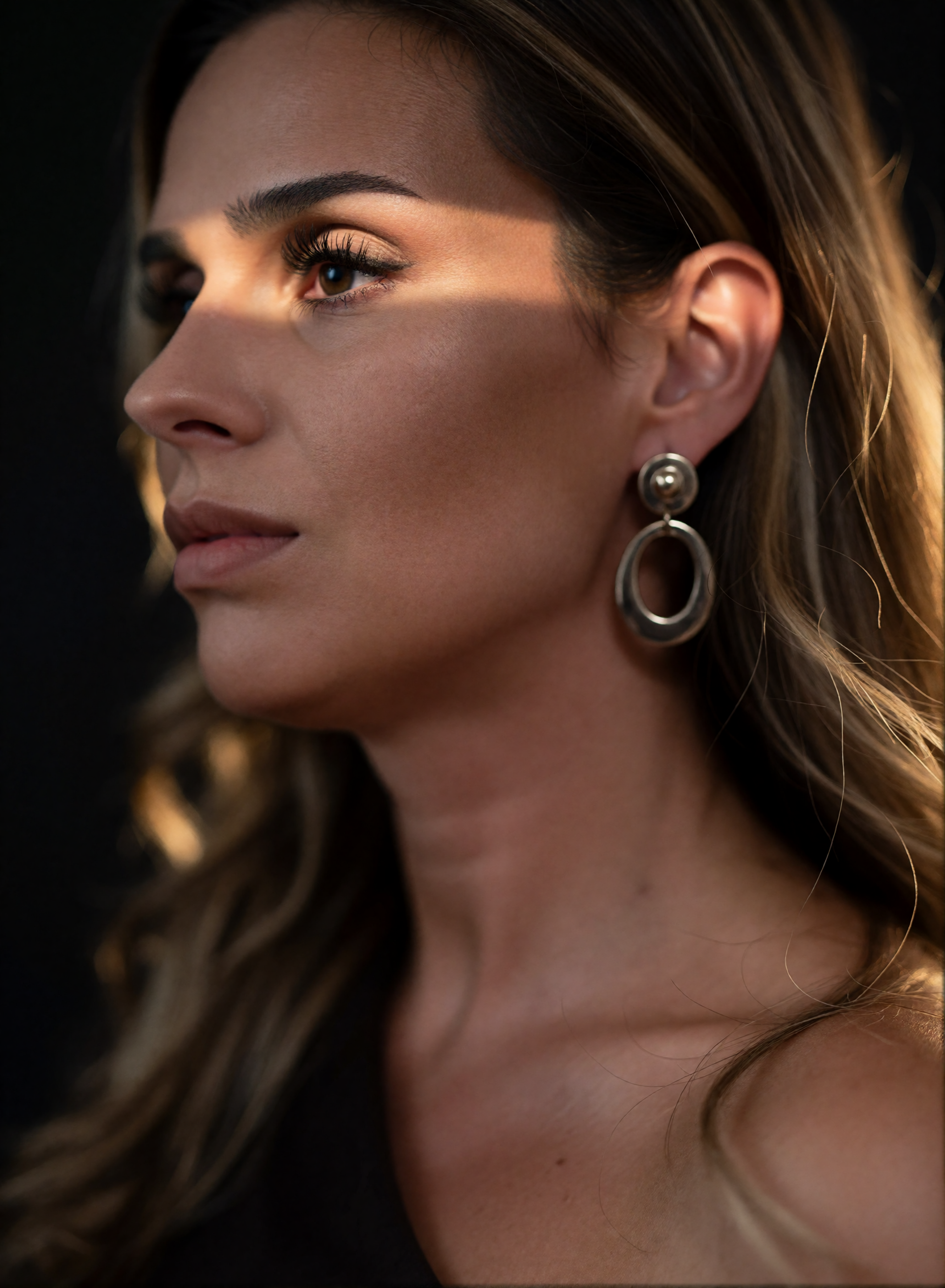 Digital twin of Nicole Funken in a beauty close-up with closed eyes and a striking eyeliner in warm sunlight.