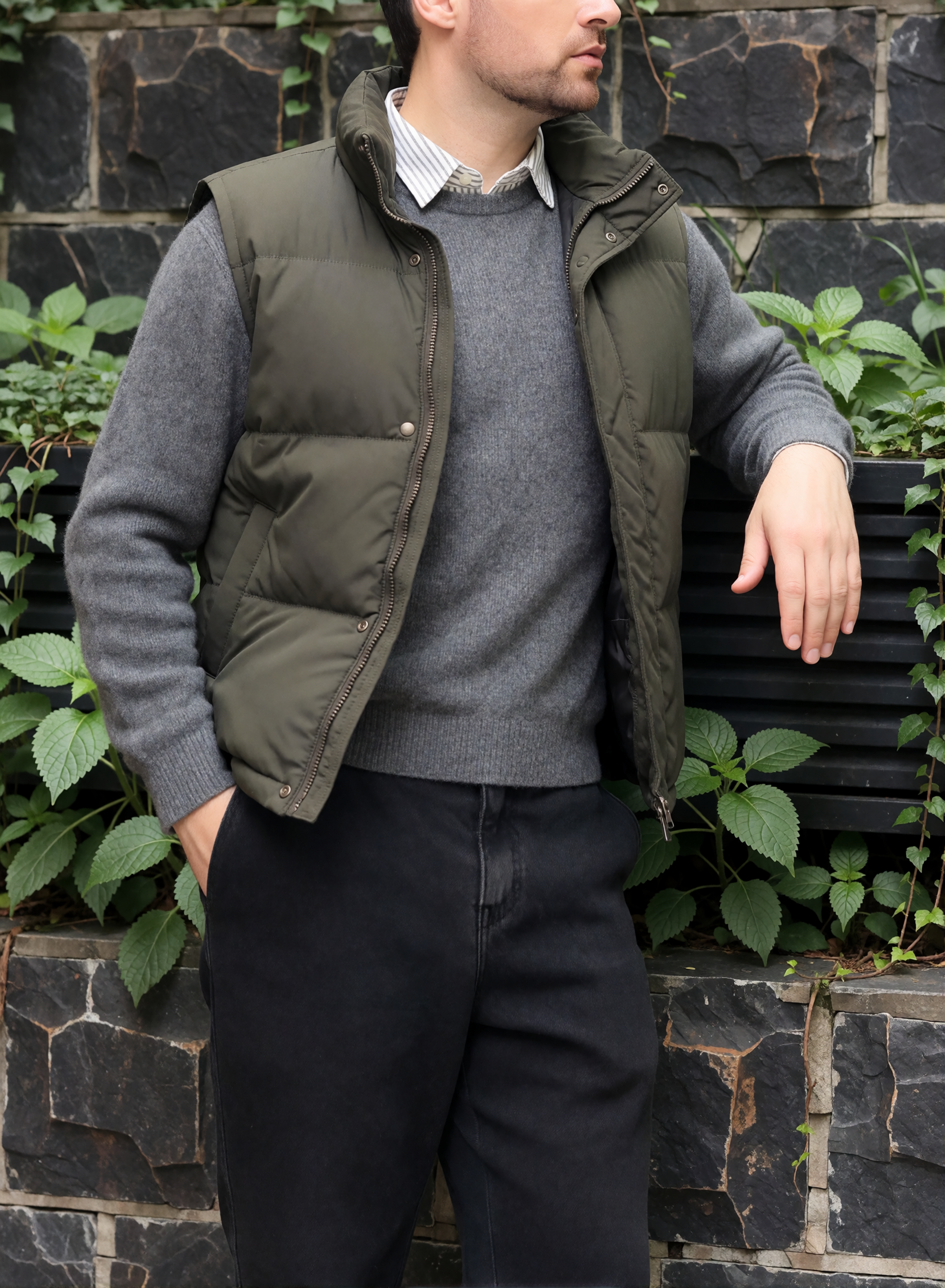 Digitaler Zwilling von Bruno Dias mit olivgrüner Steppweste, grauem Pullover und gestreiftem Hemd vor einer begrünten Steinwand.