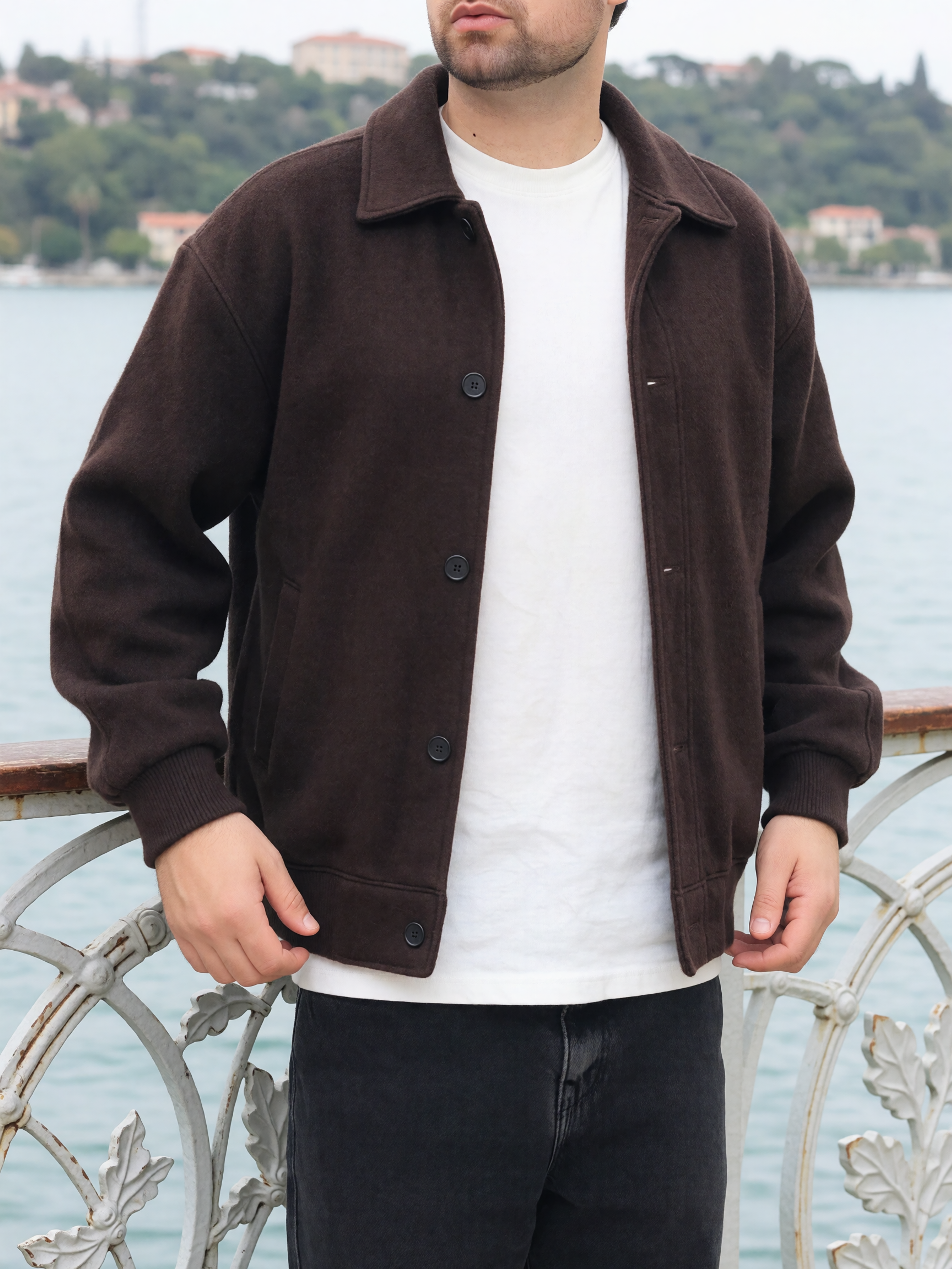 Digitaler Zwilling von Bruno Dias in brauner Jacke, weißem T-Shirt und schwarzer Hose an einer Uferpromenade.