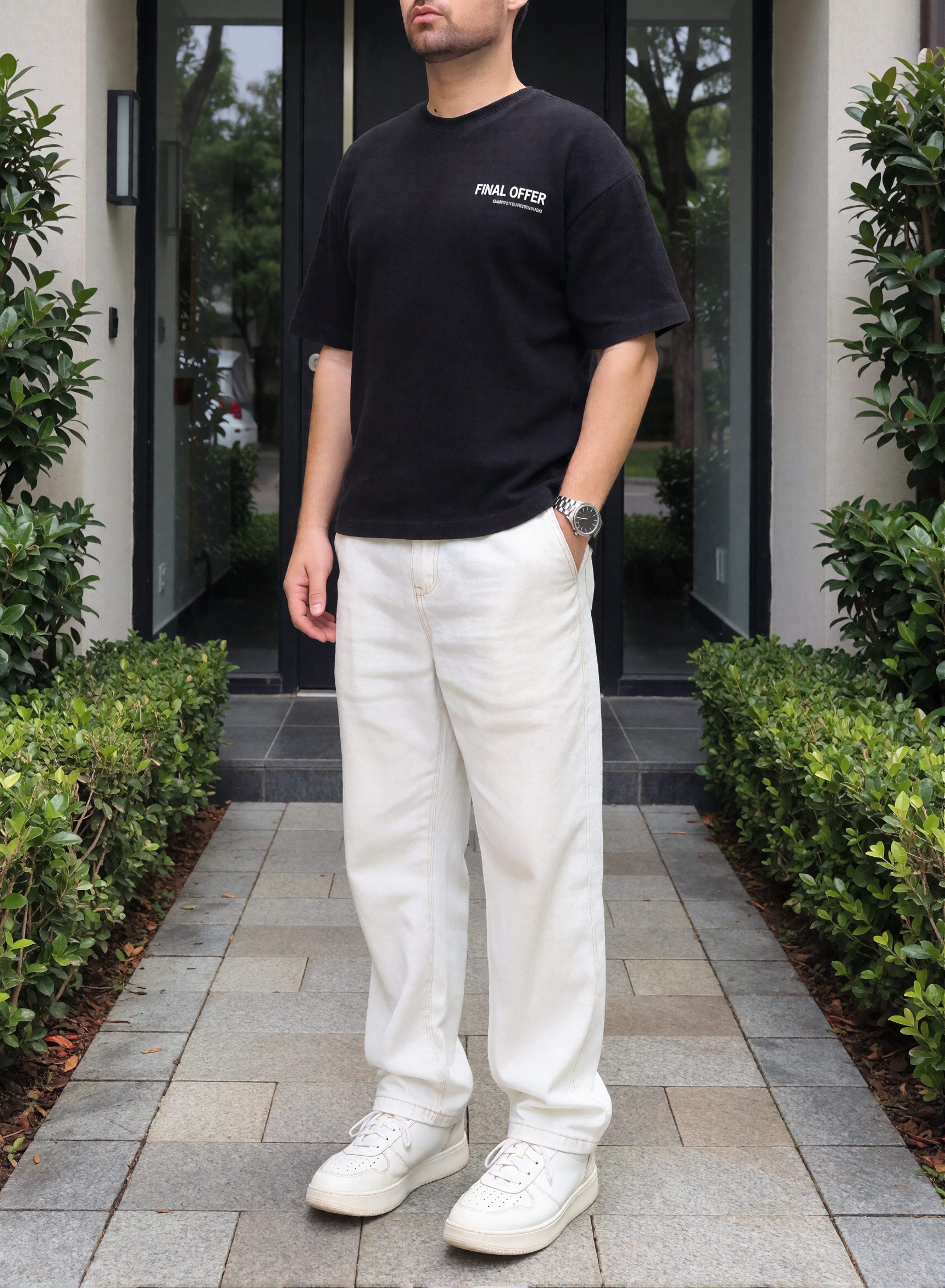 Digitaler Zwilling von Bruno Dias im schwarzen T-Shirt, weißer Hose und weißen Sneakern vor einem modernen Hauseingang mit grünen Hecken.
