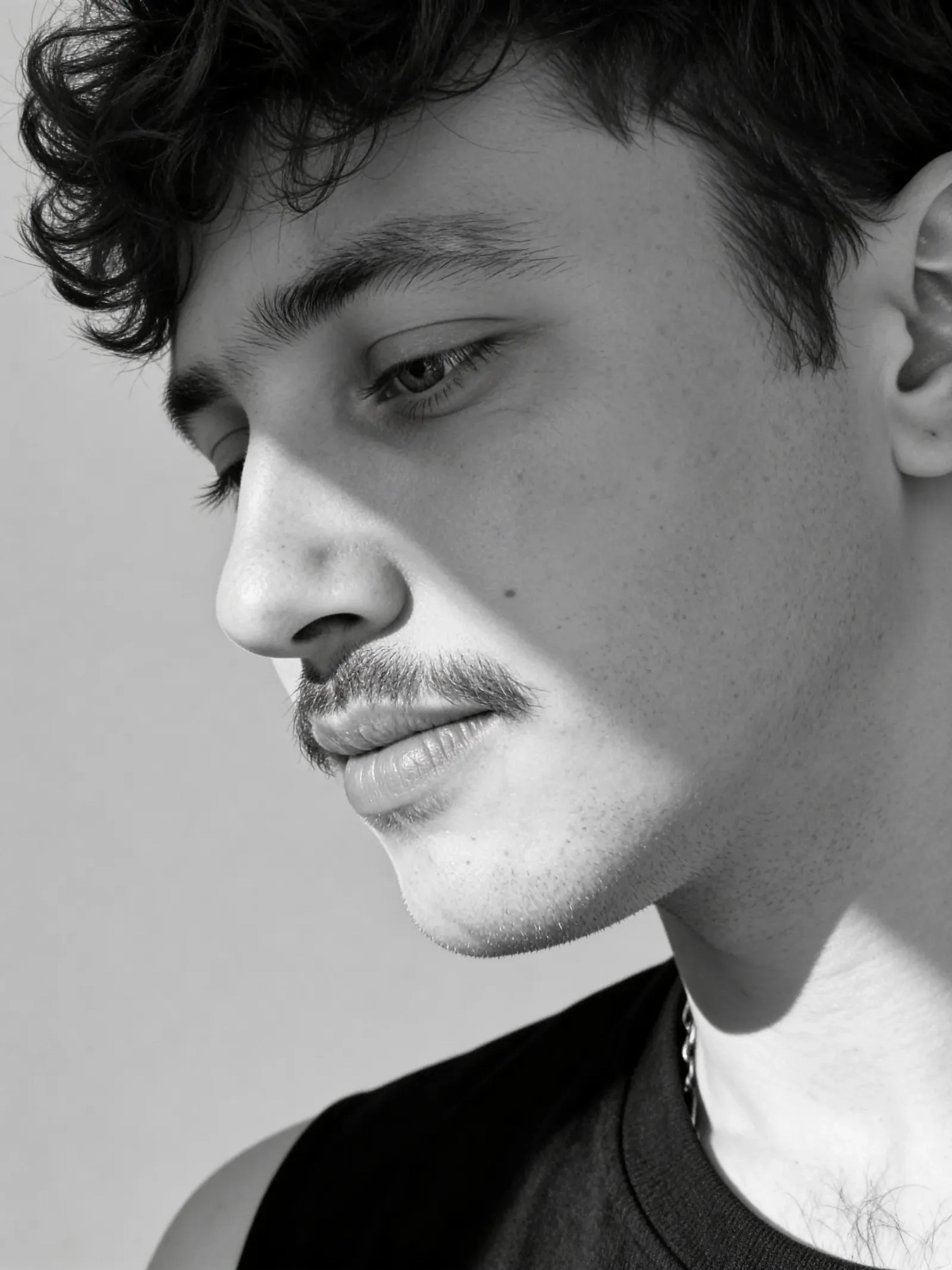 Schwarzweiß-Porträt von Artur Fenina im Profil mit gesenktem Blick