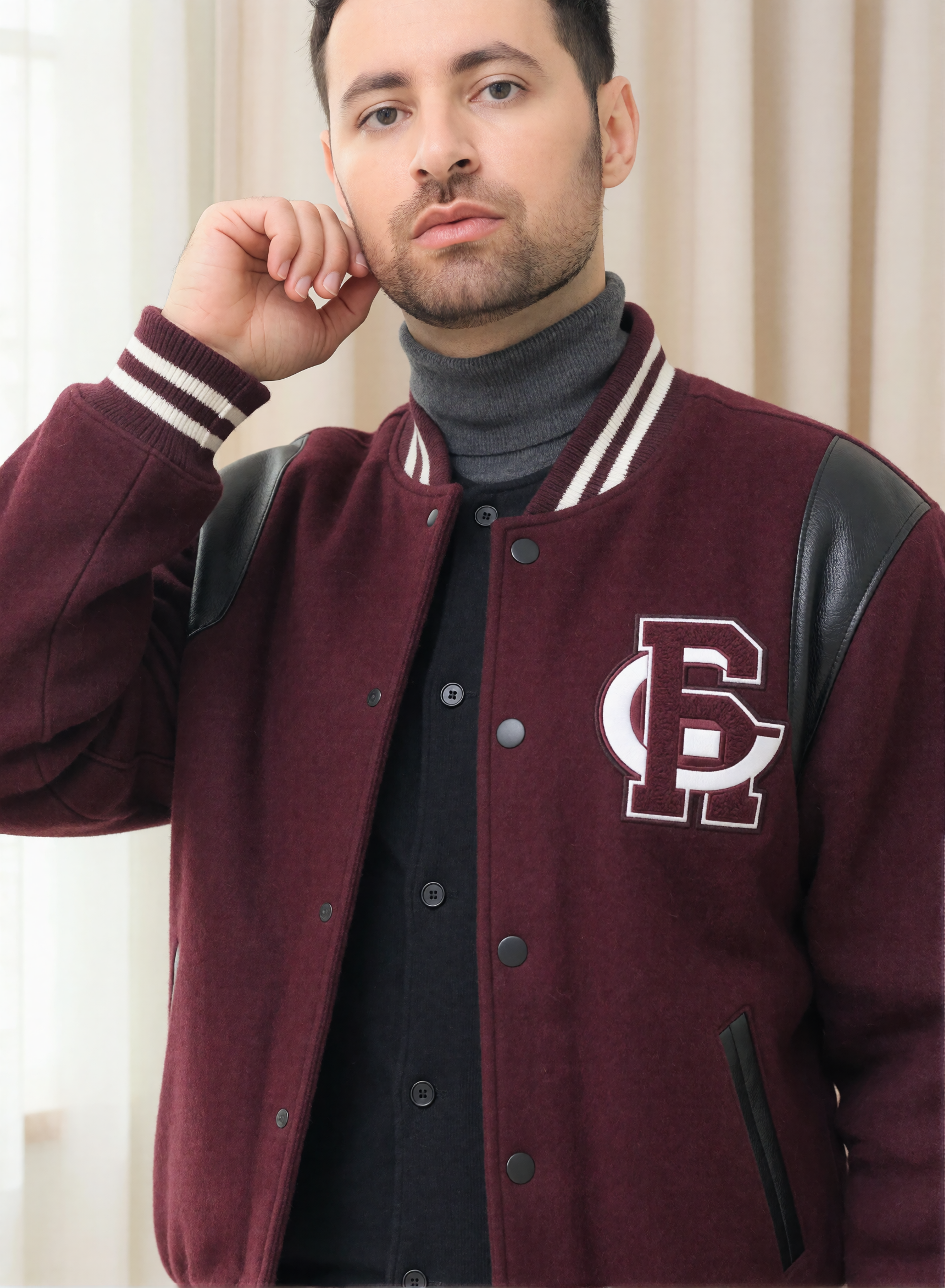 Digitaler Zwilling von Bruno Dias in bordeauxroter Collegejacke mit Lederdetails und grauem Rollkragenpullover vor hellen Vorhängen.