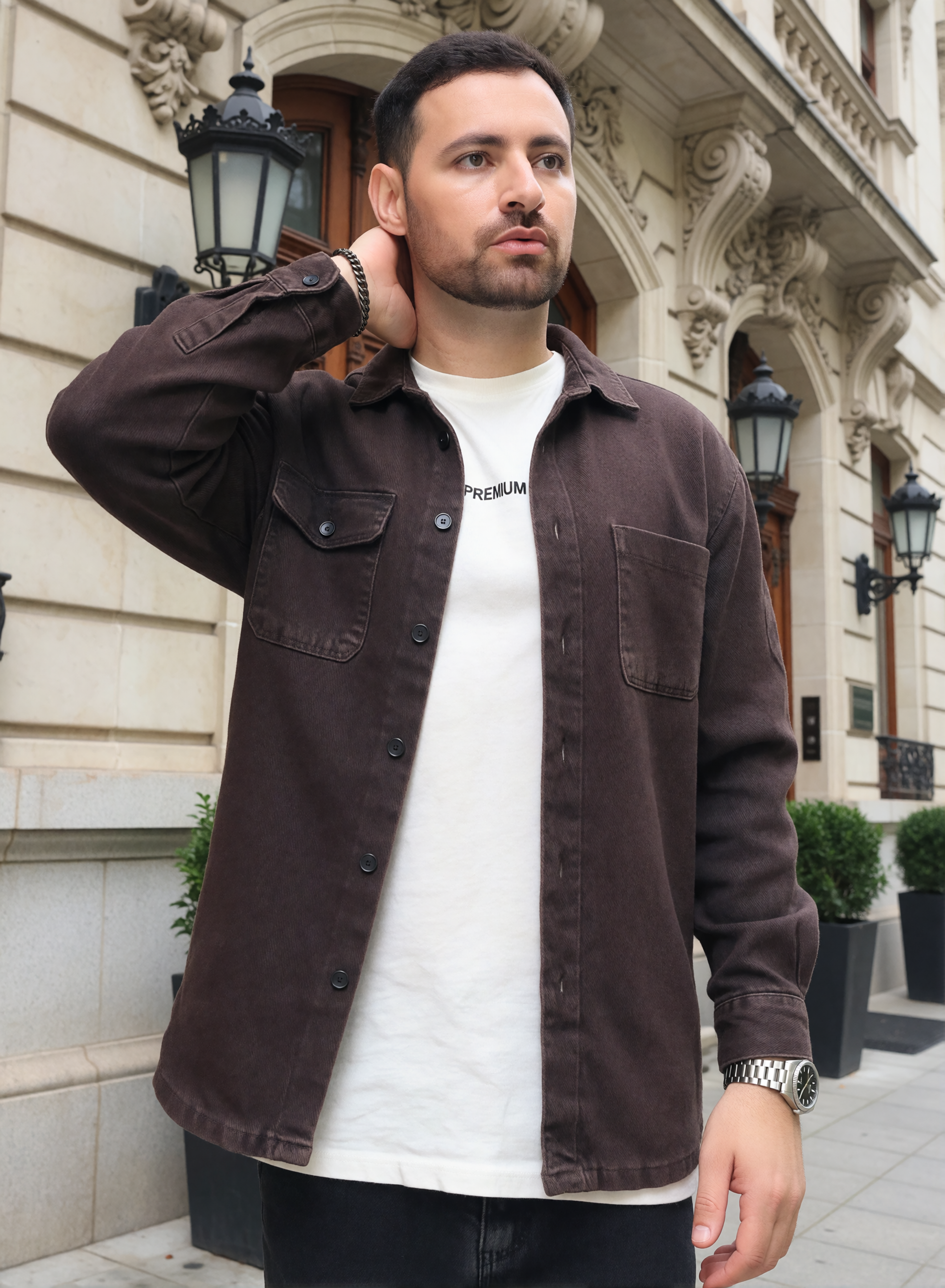 Digitaler Zwilling von Bruno Dias im braunen Overshirt und weißen T-Shirt vor einer historischen Gebäudefassade.