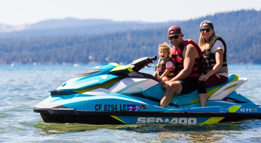 Two adults and a small child on a jet ski on Lake Tahoe