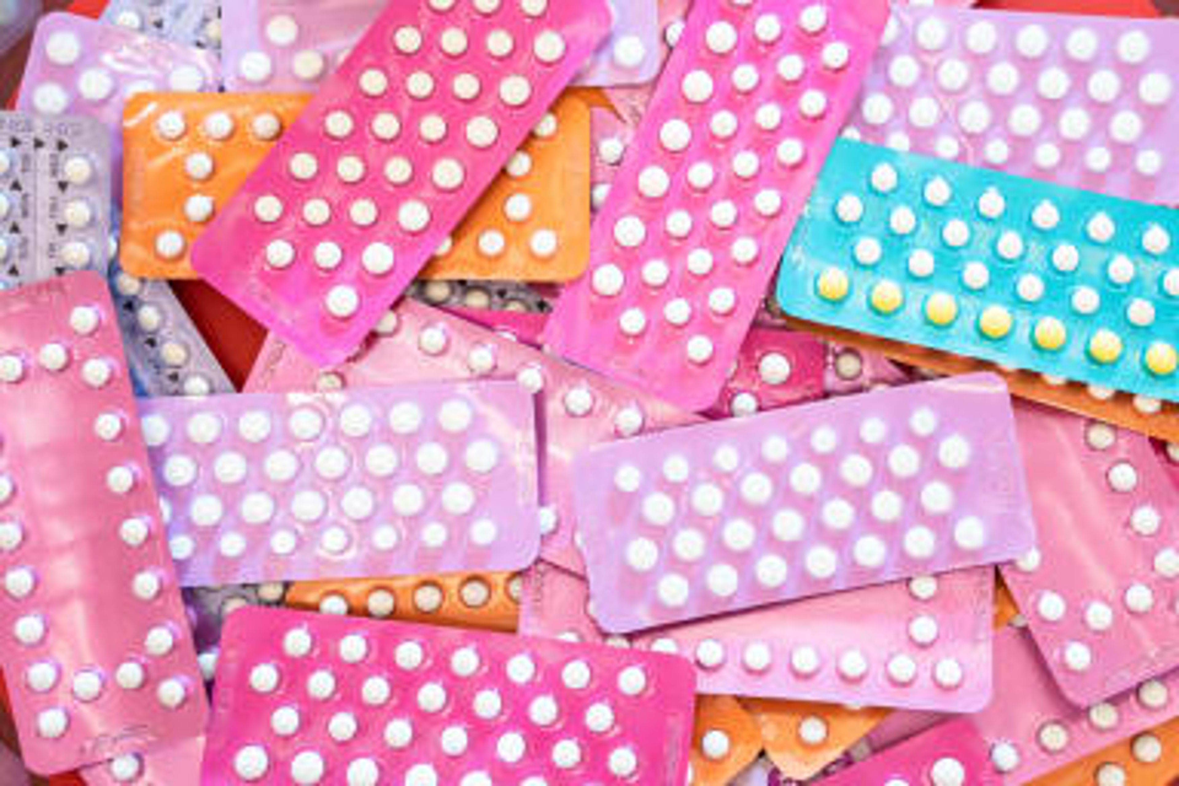 a pile of different colored birth control pills on a table .