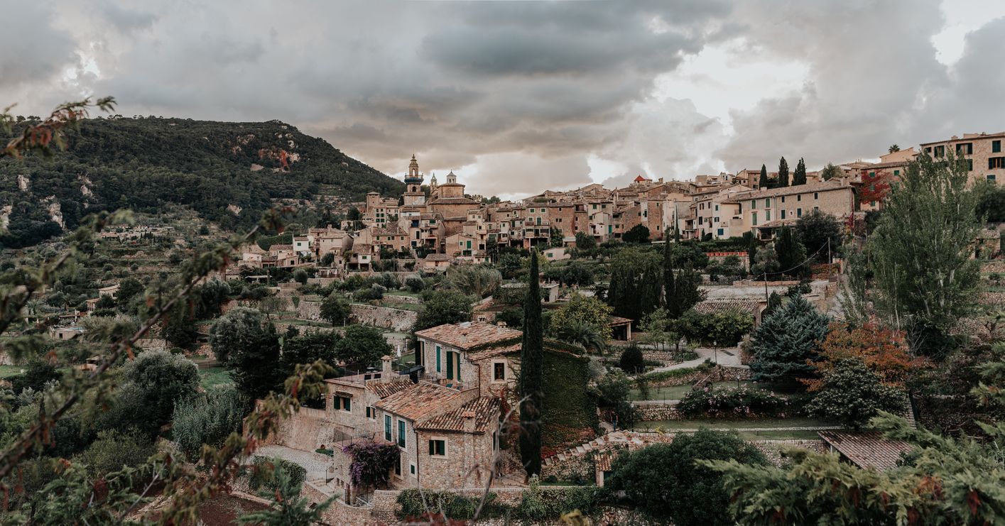 Utsikt over en spansk fjellandsby med historiske hus og grønt landskap.