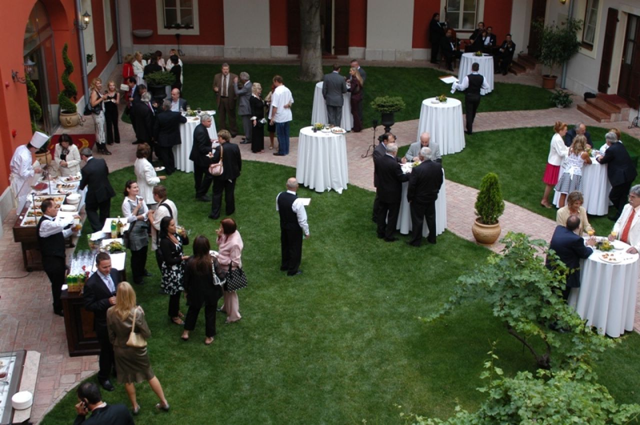 Bryllupsmottakelse i en historisk bygård i Budapest med gjester som mingler i gårdsrommet.