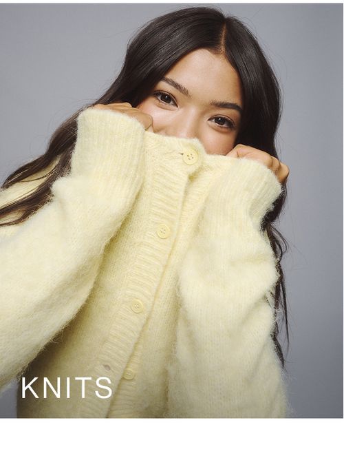 Young girl wearing a yellow knit cardigan. SHOP TEEN KNITWEAR.