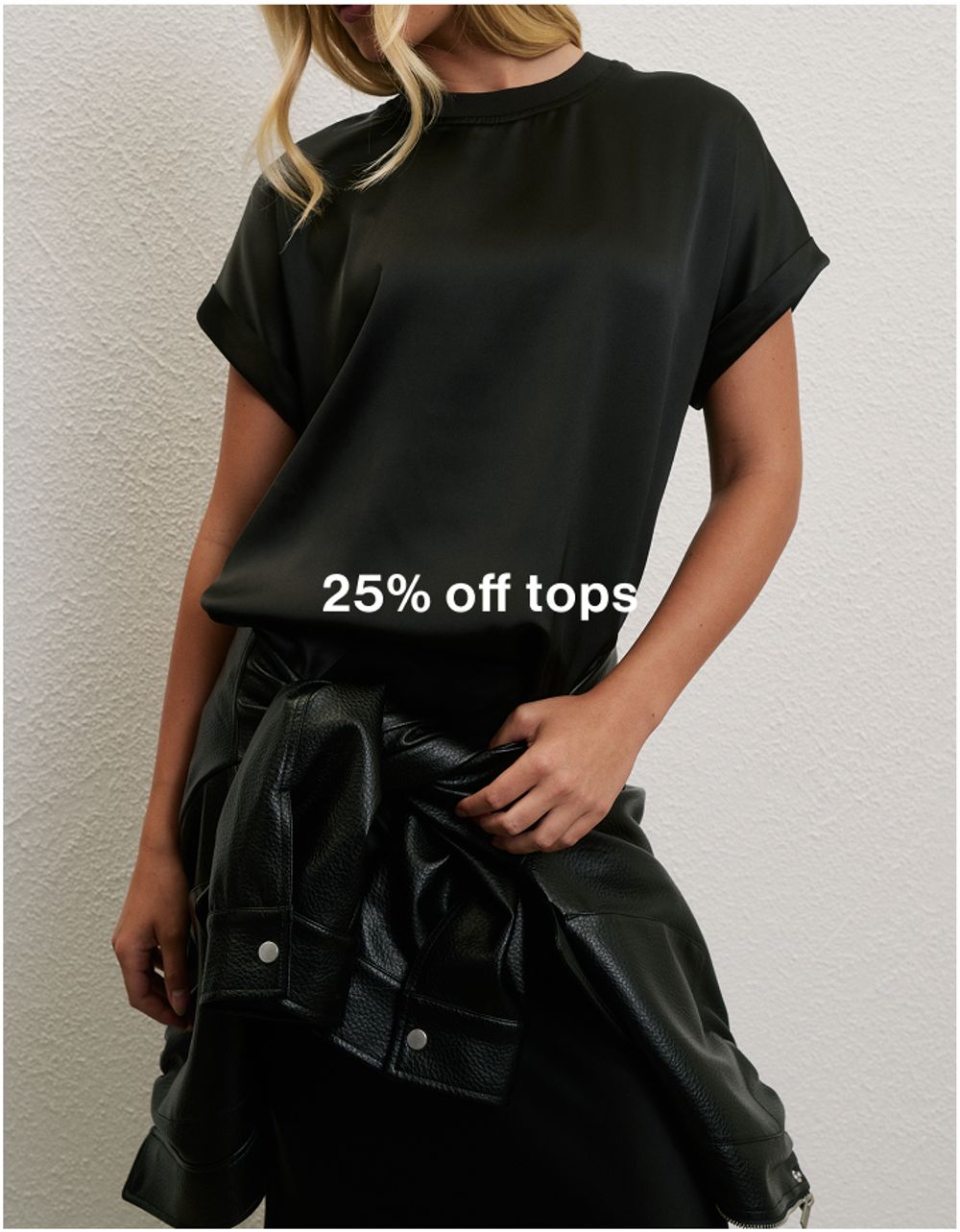 Model wearing a black halter top, promoting 25% off tops.