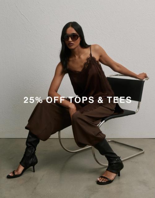 Model seated in a black chair against a neutral backdrop, wearing a brown lace camisole paired with matching brown pants and black open-toe boots. Shop tops.