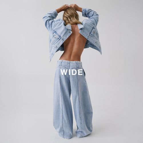 Model adjusting light wide-leg jeans – Wide fit.