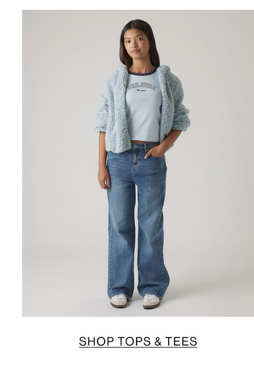 Girl in light blue top and wide-leg jeans – Kids Shop Tops & Tees.