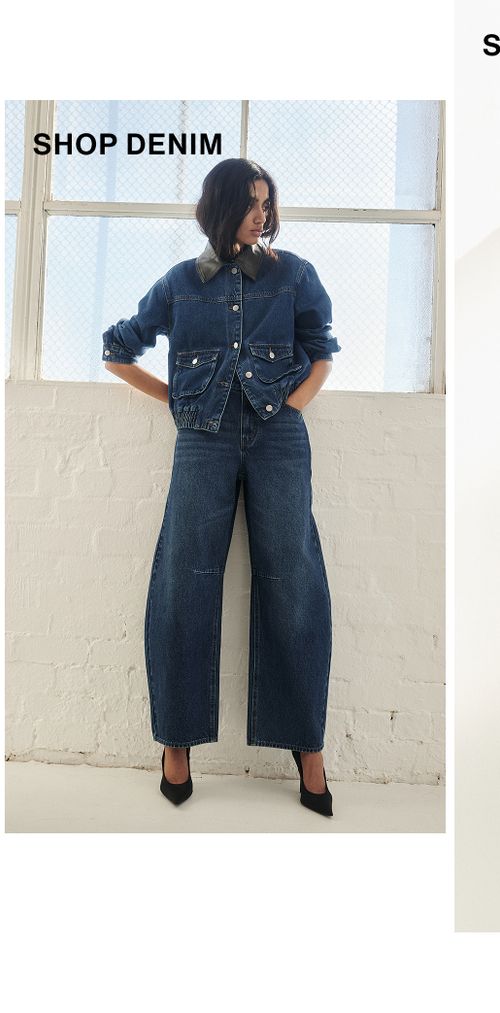 Model posing in a blue denim set in a studio. SHOP DENIM.
