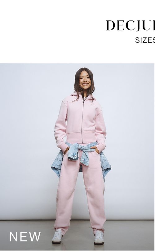 Young girl wearing a light pink sweat tracksuit set. SHOP NEW TEEN.