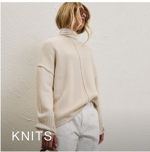 Model wearing a white knit jumper. SHOP KNITS.