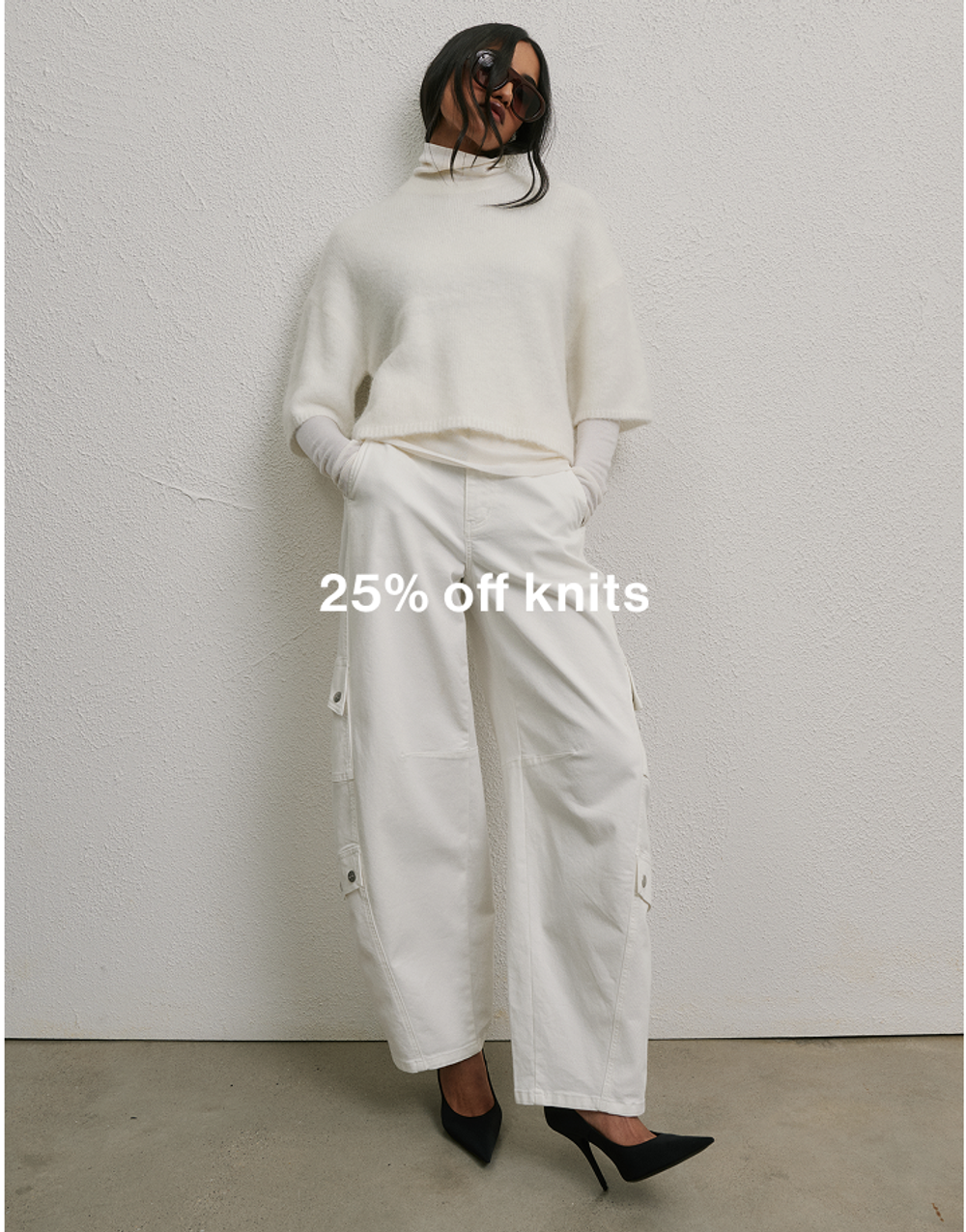 Model wearing an all-white fur knit with white denim, promoting 25% off knits