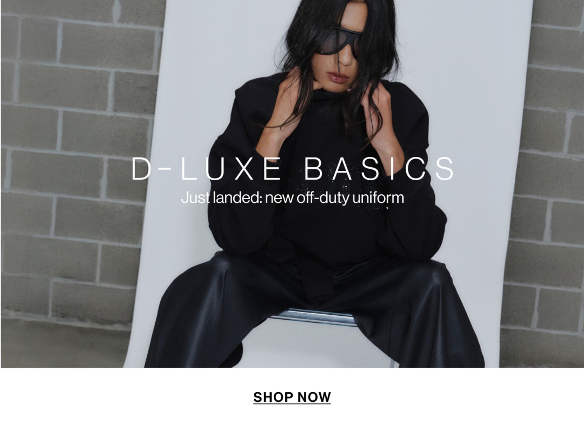 Model wearing a black bomber in a studio. Text reads D-LUXE BASICS