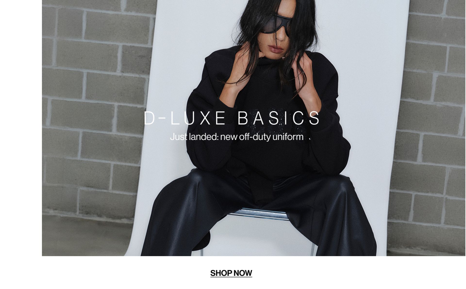 Model wearing a black bomber in a studio. Text reads D-LUXE BASICS