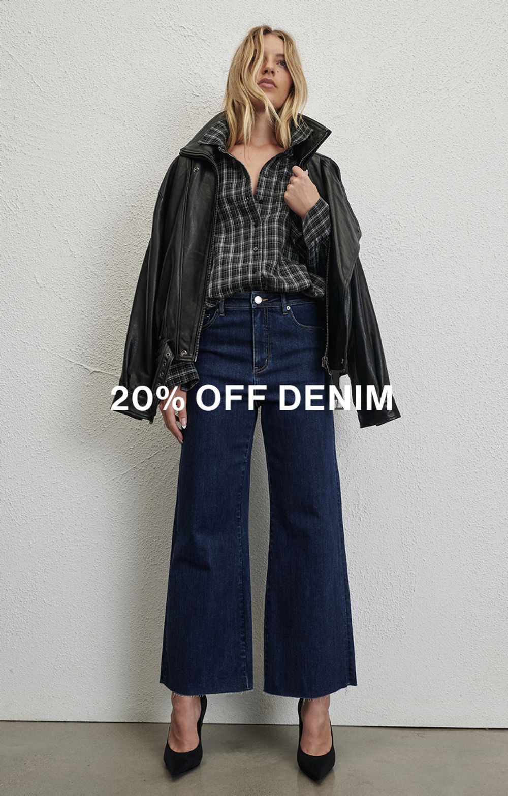 Model wearing a black long sleeve top and jeans. Text reads 20% off denim.