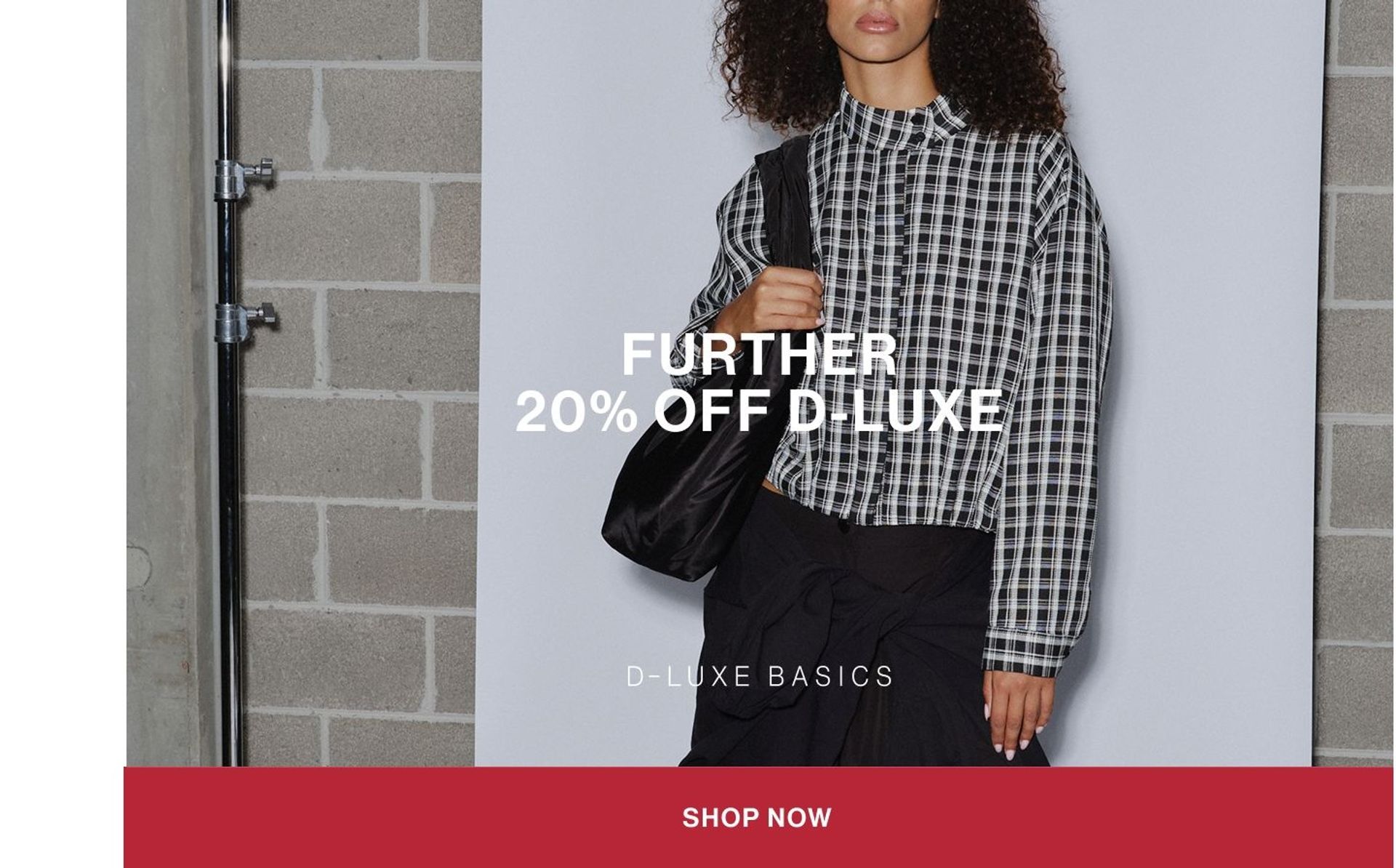 Model wearing a black check shirt in a studio. Text reads FURTHER 20% OFF D-LUXE.