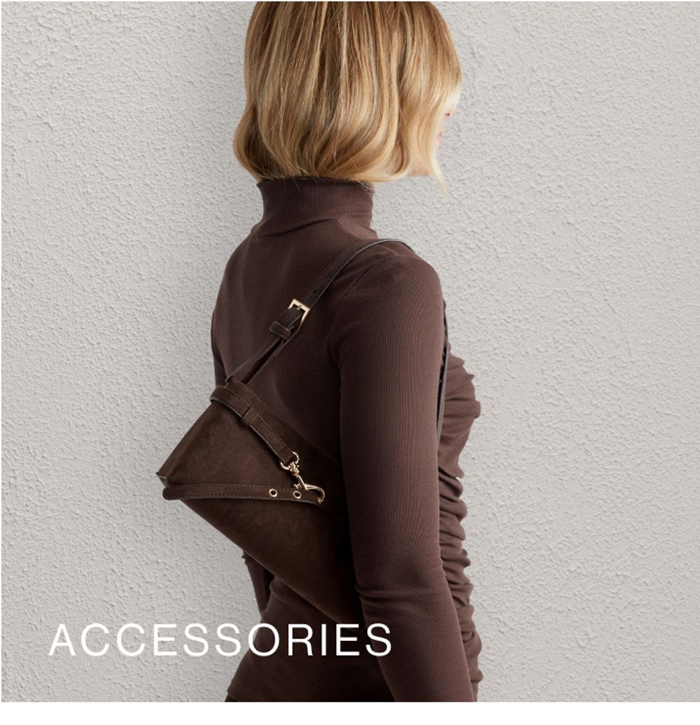 Model wearing a brown high neck long sleeve top with a brown shoulder bag. SHOP ACCESSORIES.
