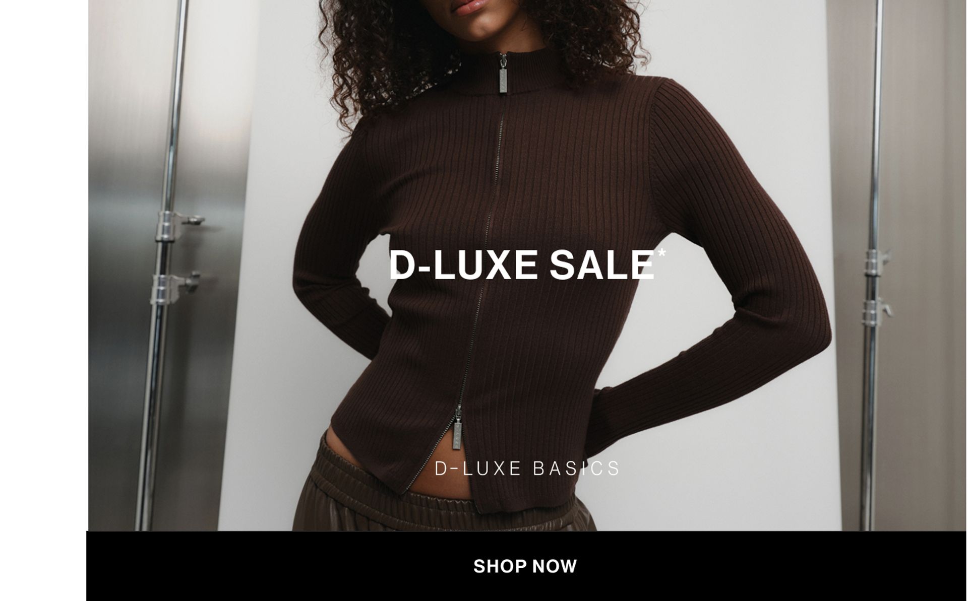 Model wearing a brown knit zip-up top in a studio. Text reads D-LUXE SALE.