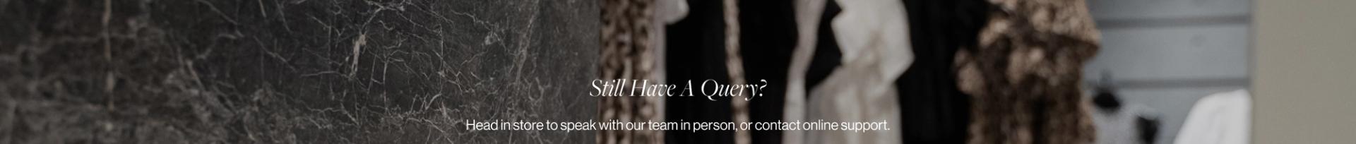 A blurred photo of a clothing store with the text "Still Have a Query?"