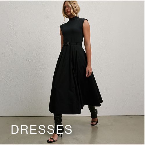 Model wearing a black high neck midi dress. SHOP DRESSES.