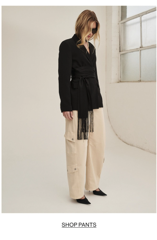 Model posing in a black blazer with cargo pants in almond