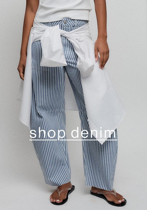 Close-up of striped blue-and-white pants styled with a white top and denim tie detail.