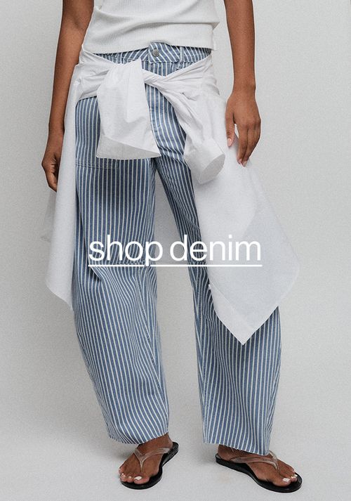 Close-up of striped blue-and-white pants styled with a white top and denim tie detail.