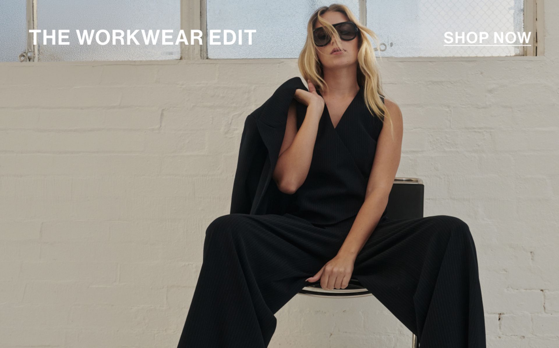 Model wearing a navy pinstripe set with text overlay: "THE WORKWEAR EDIT"