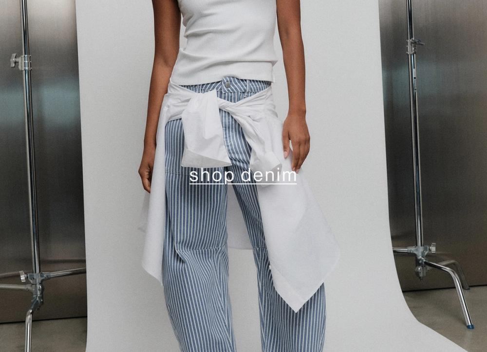 Close-up of striped blue-and-white pants styled with a white top and denim tie detail.