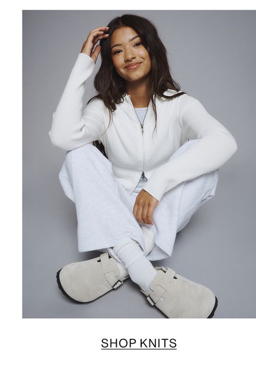 Young girl dressed in a white hoodie and matching sweatpants.