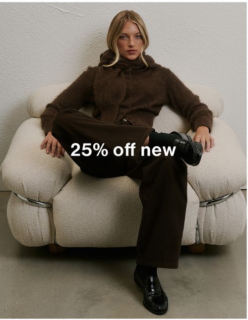 Woman in oversized brown suit sitting in office chair wearing sunglasses, promoting 25% off new arrivals.