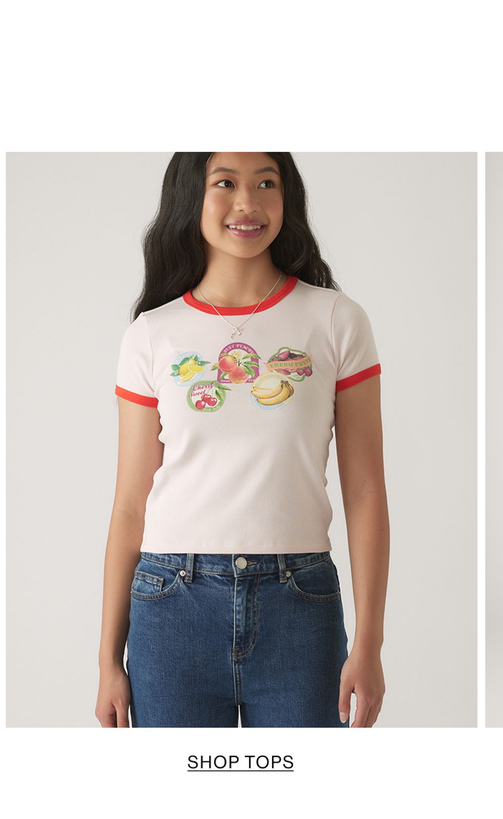 Girl wearing a white t-shirt with text that states shop tops
