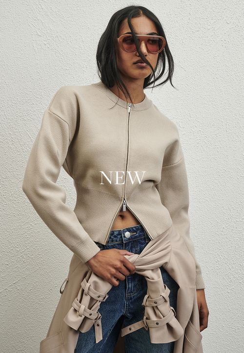 Model wearing a khaki trench. SHOP NEW.