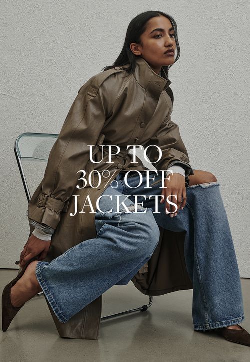 Model wearing a brown faux fur jacket. SHOP JACKETS.
