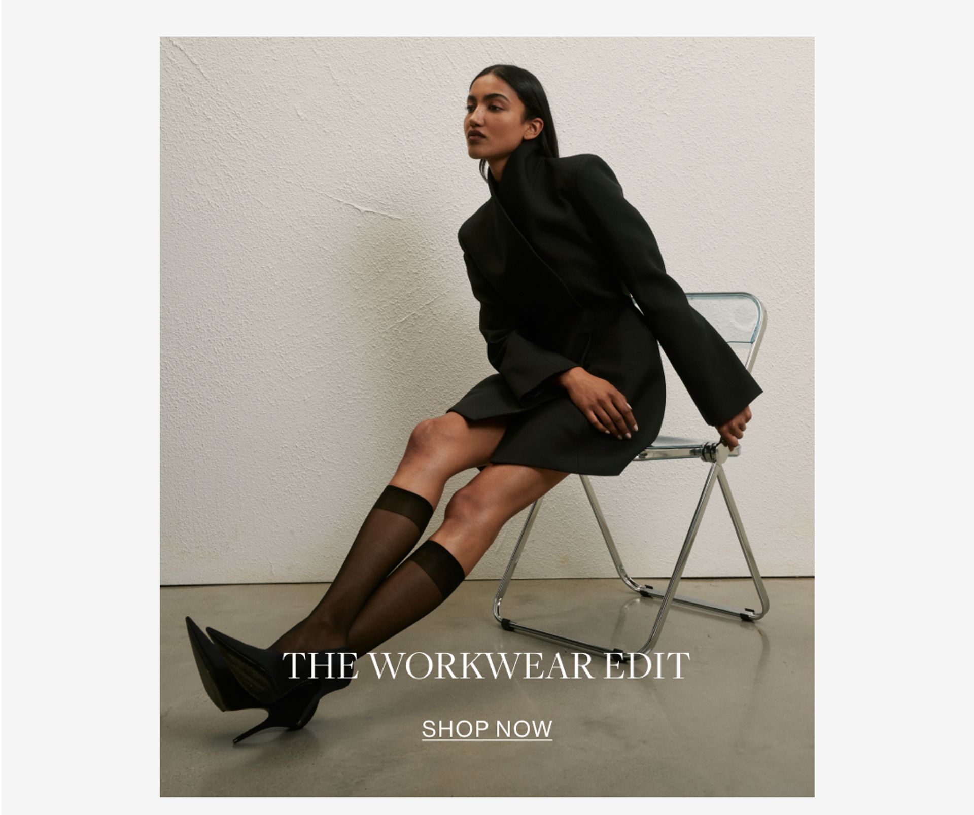 Model wearing a black high neck long sleeve mini dress. SHOP THE WORKWEAR EDIT.