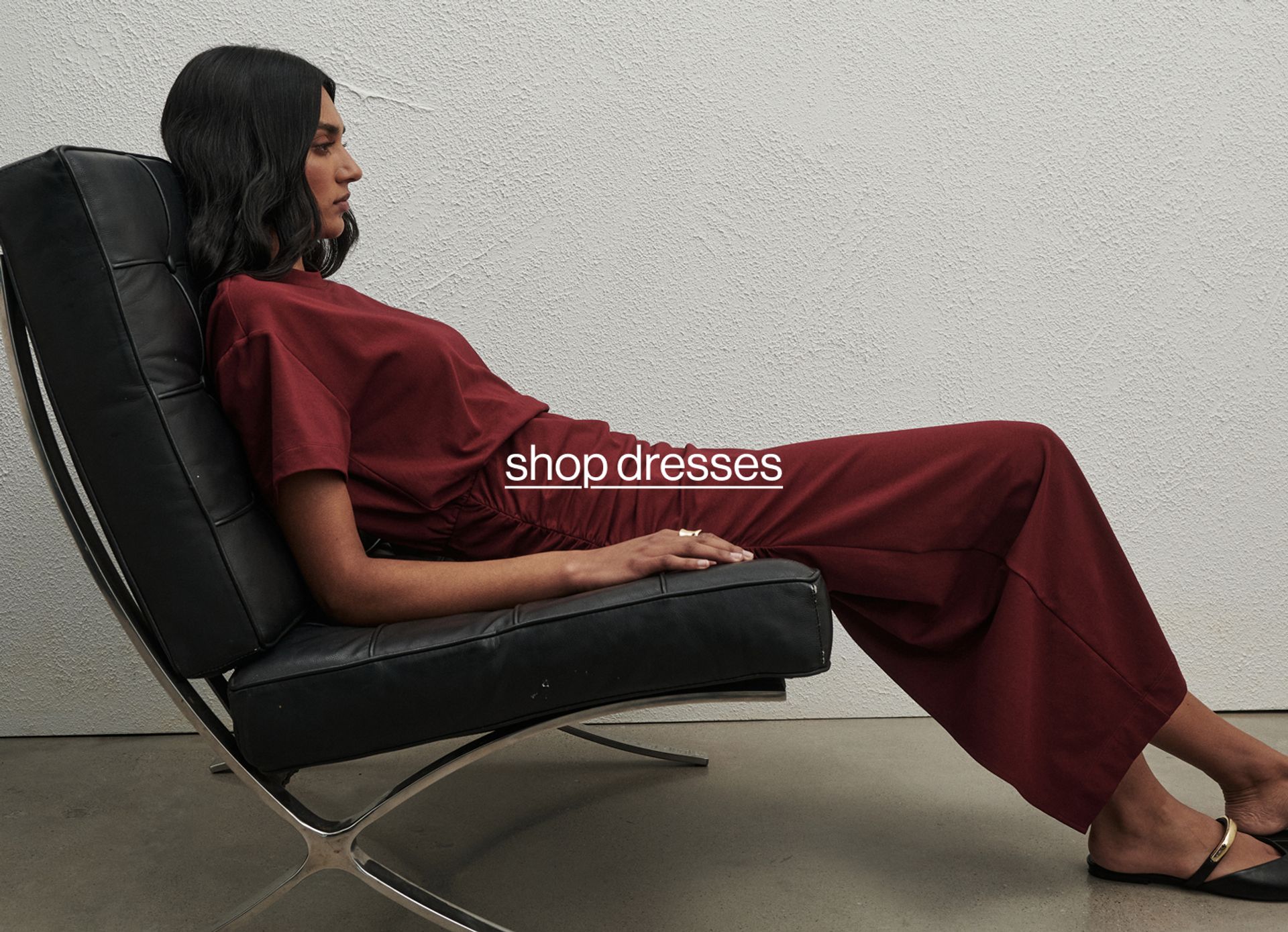 Model a sitting on a couch in a red dress