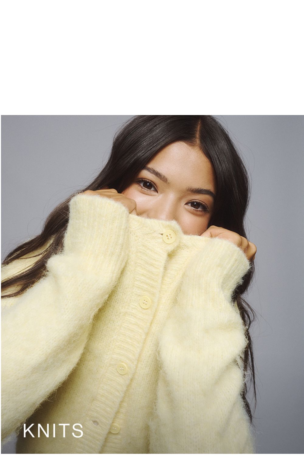 Young girl wearing a yellow knit cardigan. SHOP TEEN KNITWEAR.