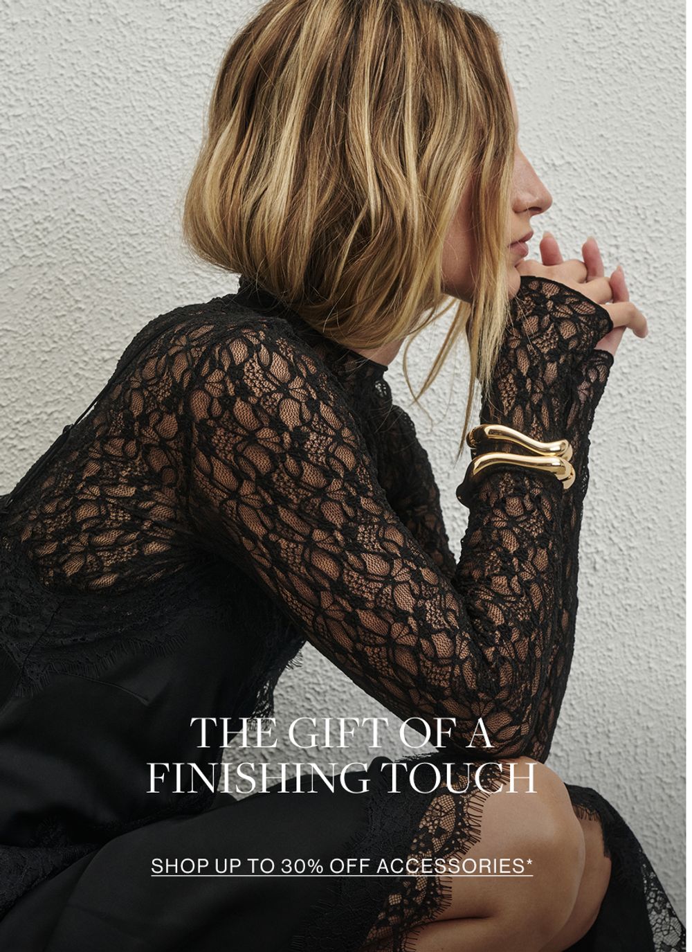 Woman in black dress and gold bangle. Text reads accessories she'll love