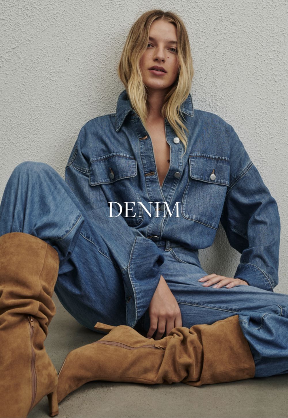 Model wearing a light denim jacket and jeans. SHOP DENIM.