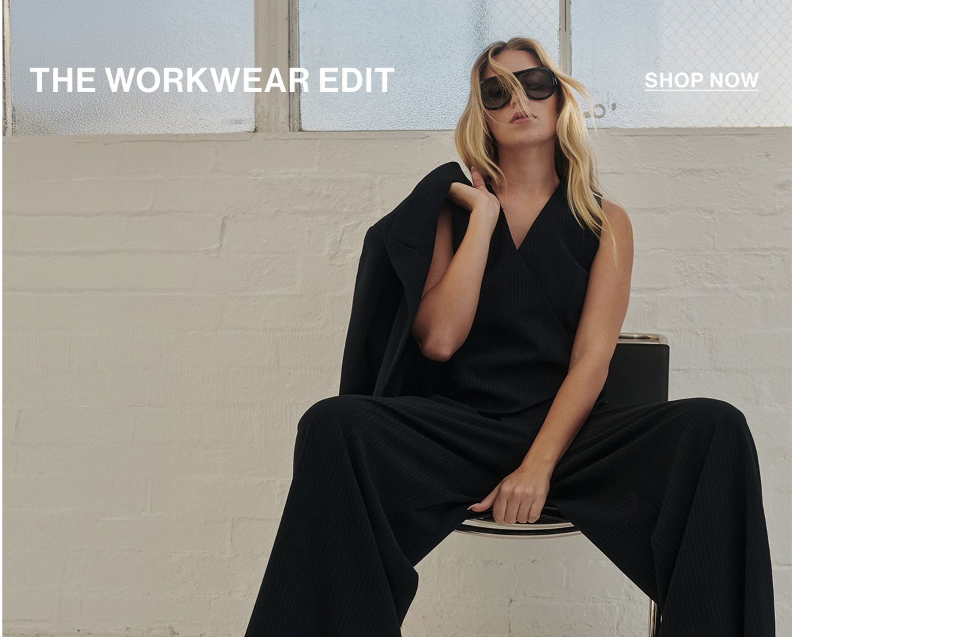 Model wearing a navy pinstripe set with text overlay: "THE WORKWEAR EDIT"