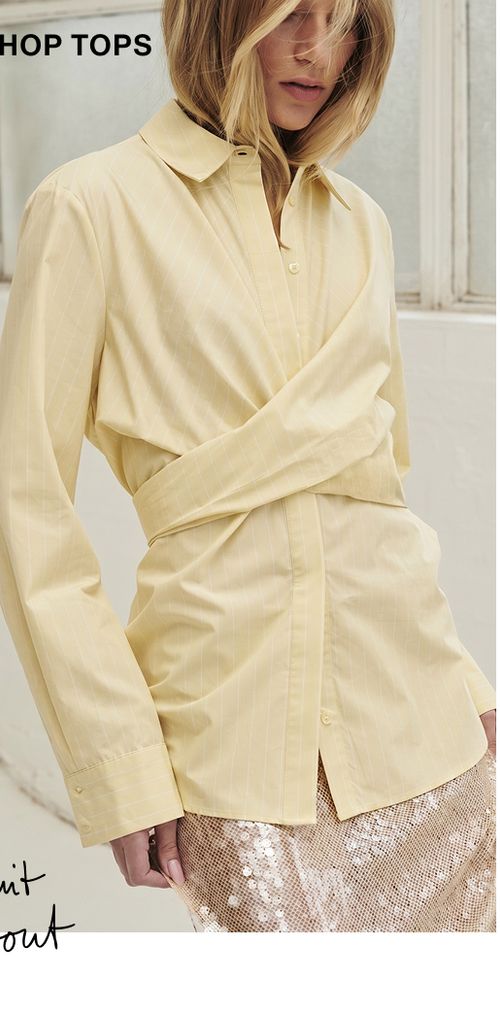 Model posing wearing a lemon coloured wrap shirt tee. SHOP TOPS.