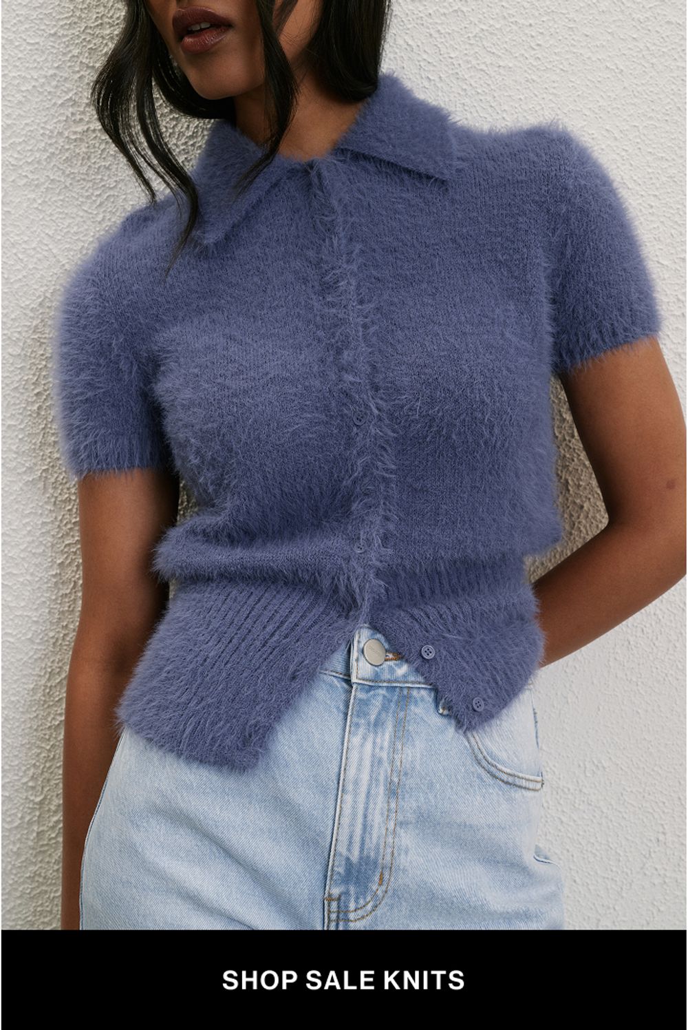 Woman wearing a blue knit jumper with text overlay "further 30% off knits"